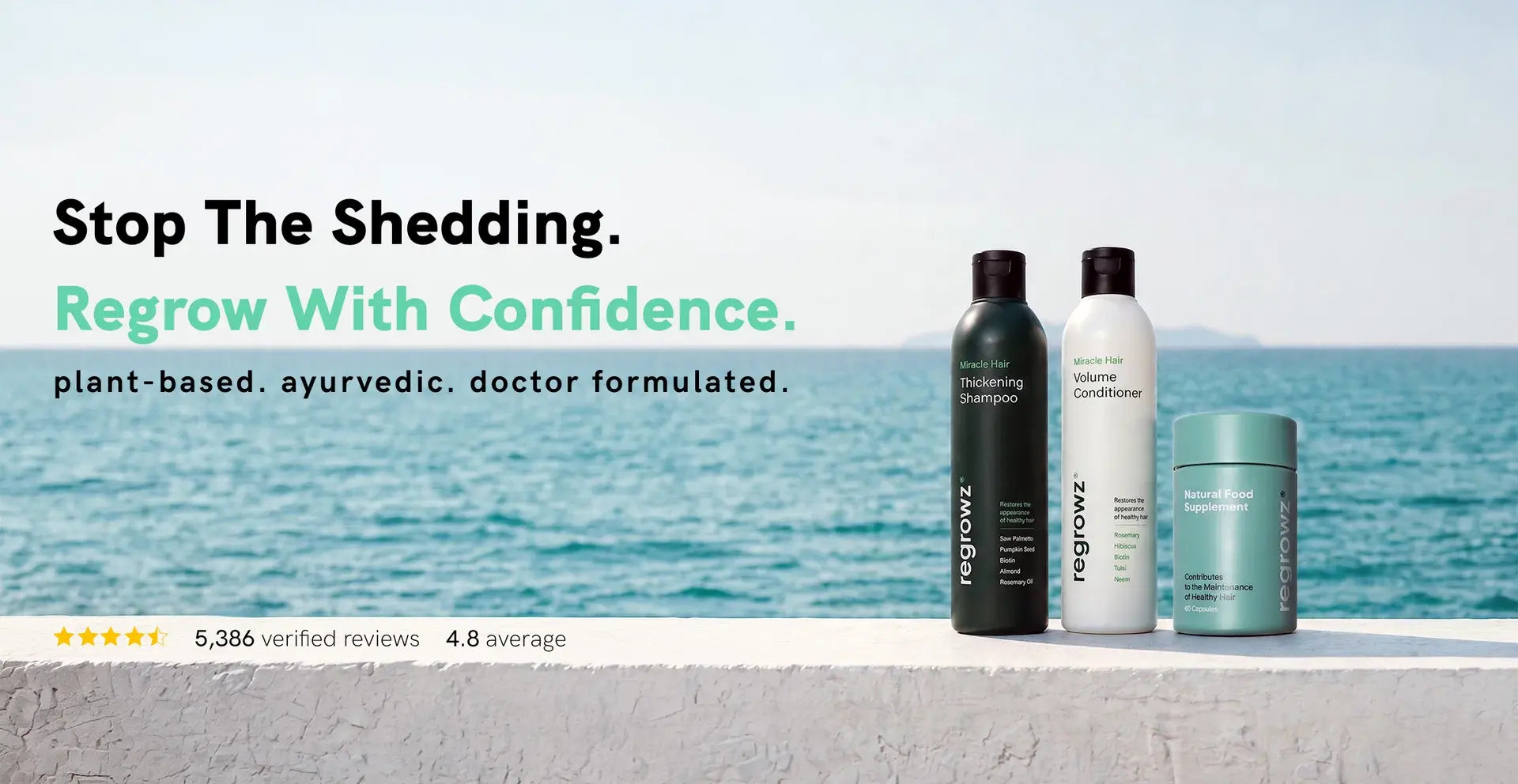 Three Regrow hair care products (two bottles and one jar) displayed on a white ledge with a scenic ocean background. Text on the left reads 'Stop The Shedding.